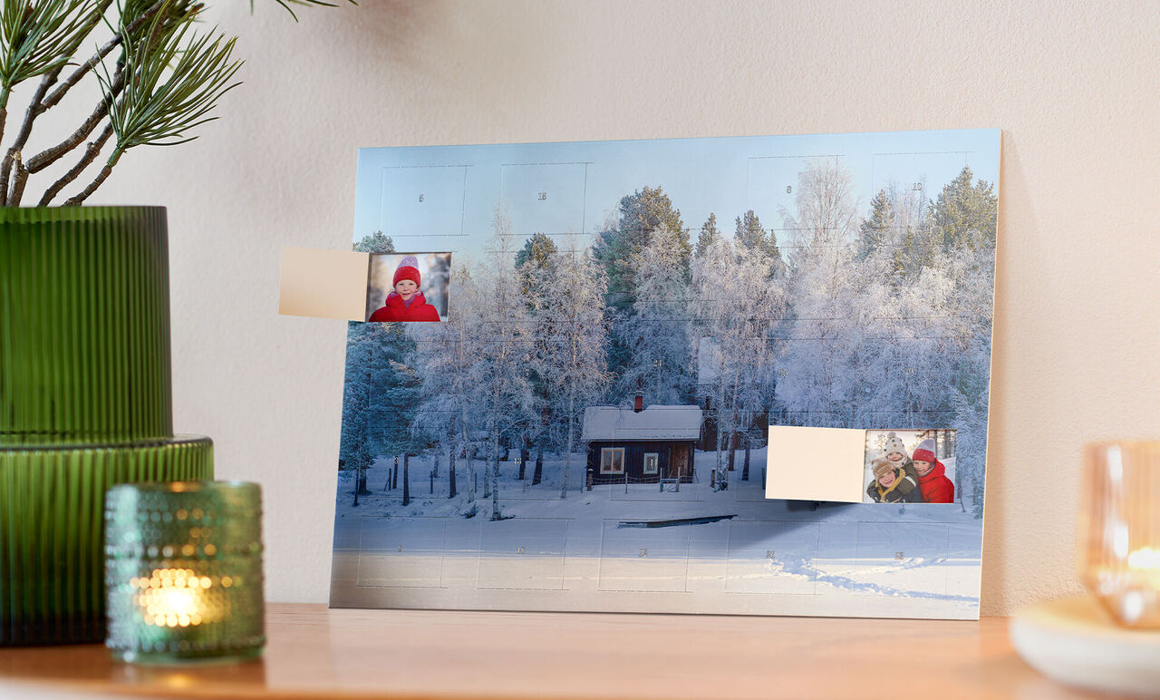 Winterlandschaft mit einem Holzhaus umgeben von schneebedeckten Bäumen