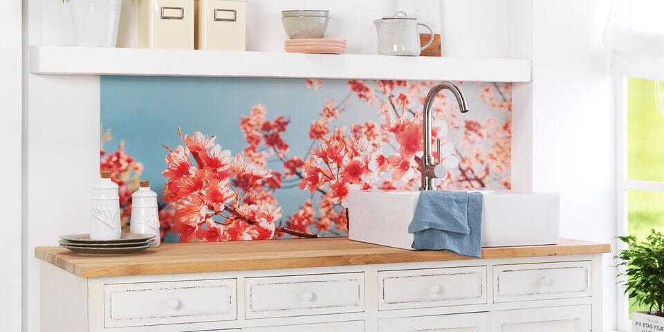 Liebevoll gestaltete Küche mit blühenden Kirschblüten als Wandbild