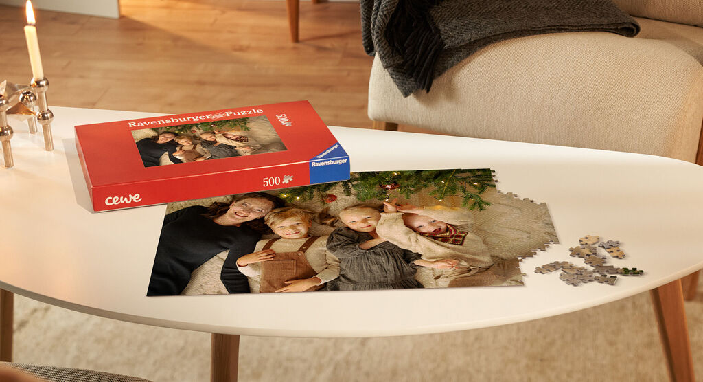 Familie entspannt beim Puzzeln mit einem CEWE Puzzle auf dem Tisch