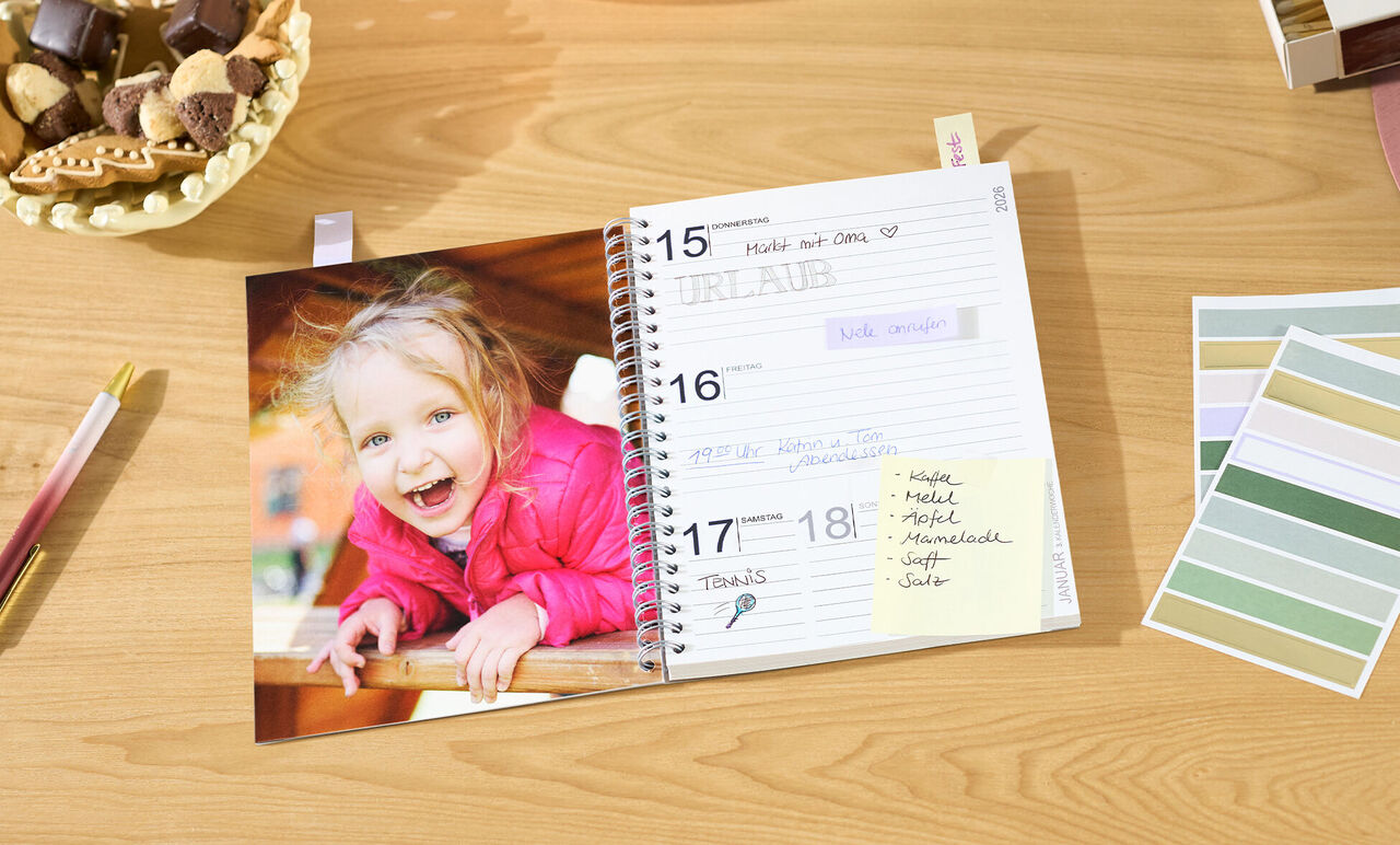 Ein fröhlicher Kalender geöffnet auf einer Seite mit Notizen und einem Foto