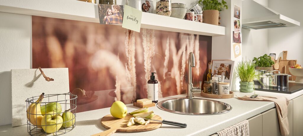 Helle Küche mit modernem Design, frischem Obst und elegantem Geschirr auf der Arbeitsfläche