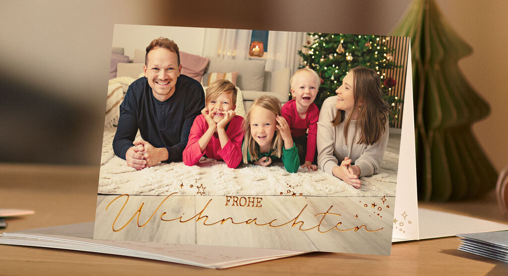 Familie feiert Weihnachten vor einem festlich geschmückten Baum
