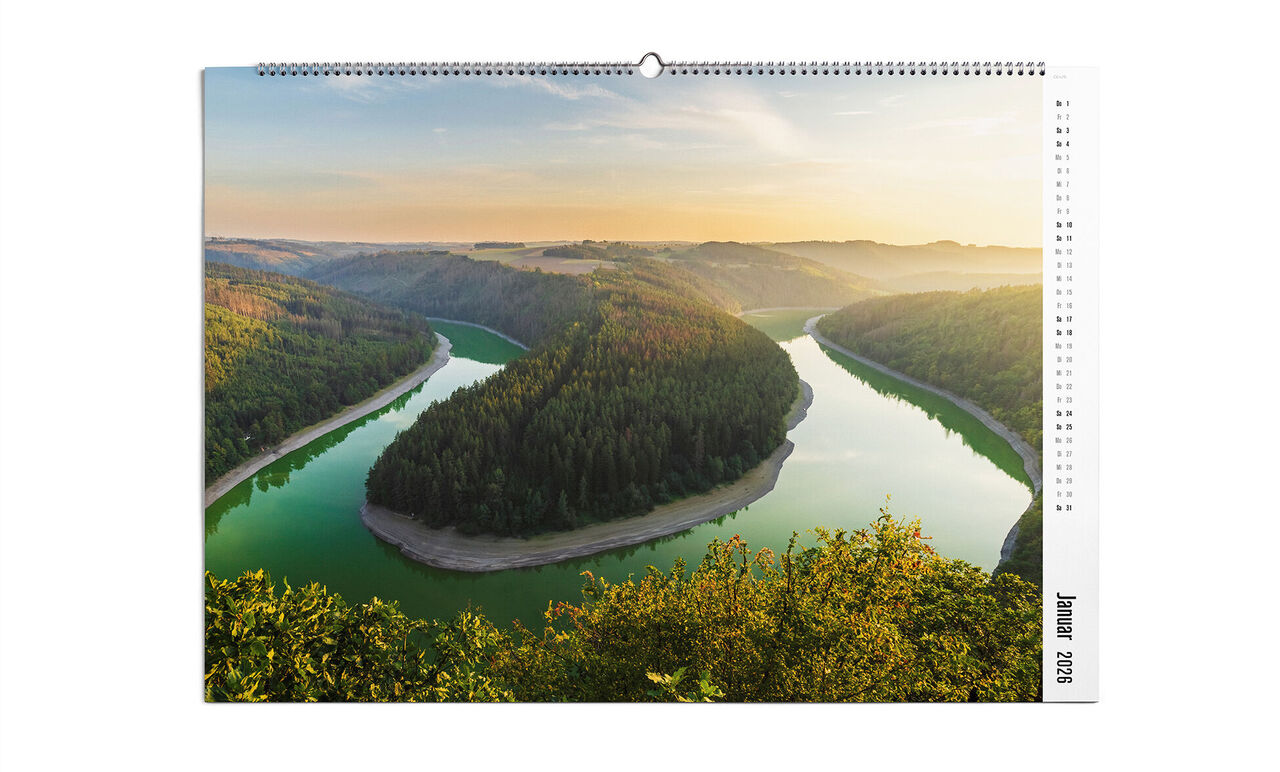 CEWE Fotokalender mit grünem Fluss und bewaldeten Hügeln beim Sonnenaufgang