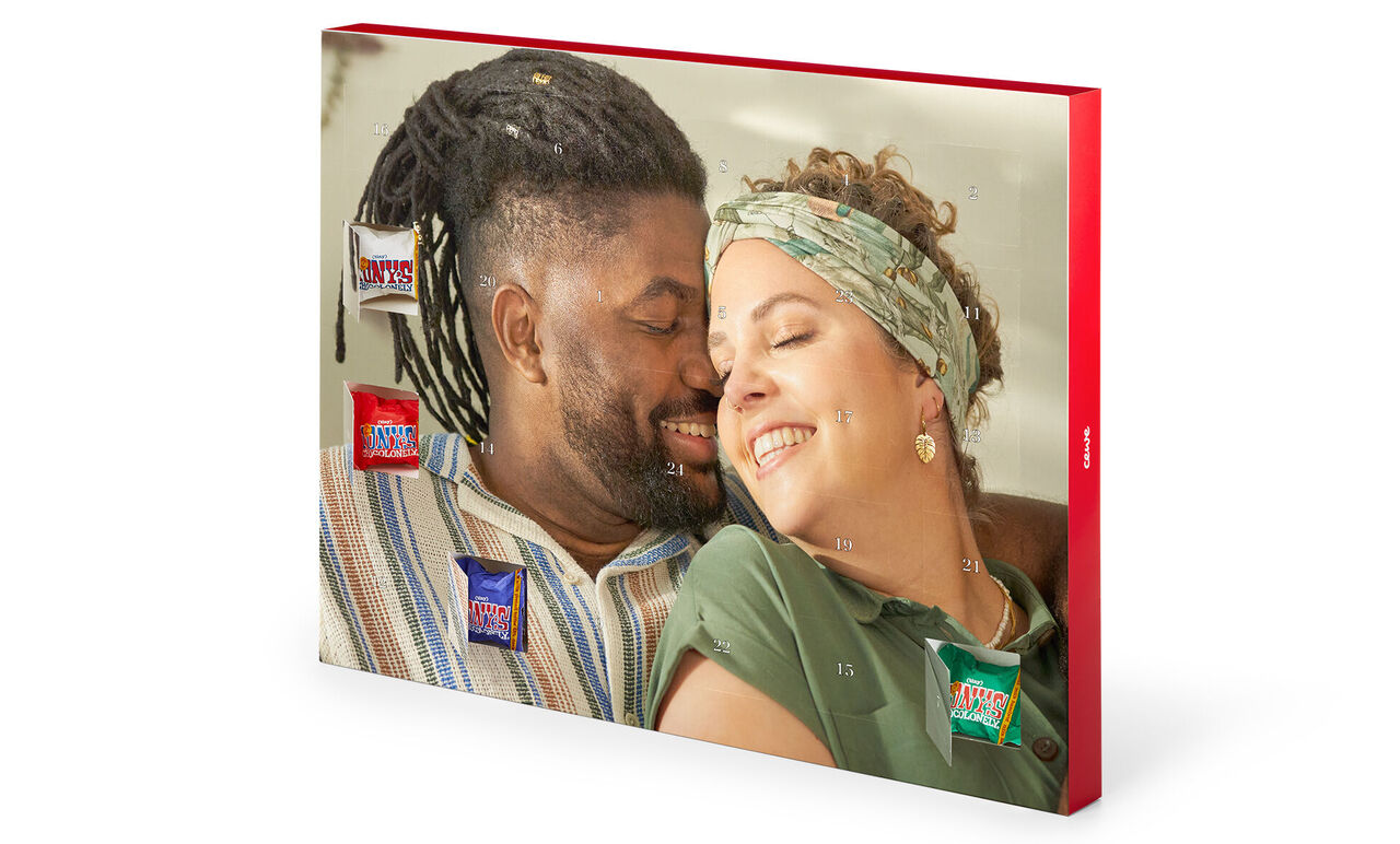 Zwei Personen liebevoll auf einer Couch, umgeben von CEWE Produkten.
