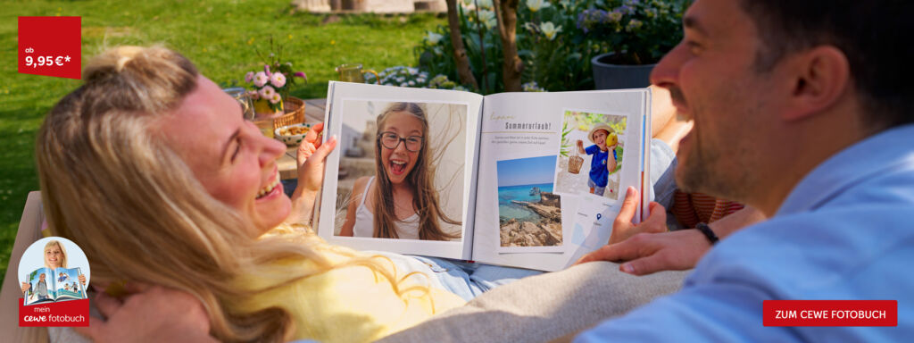 Familie betrachtet gemeinsam ein aufgeschlagenes CEWE FOTOBUCH mit Urlaubsfotos im Garten.