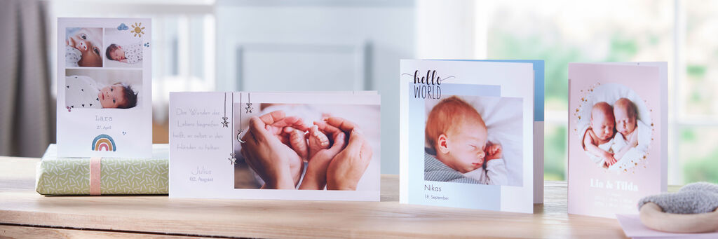 Zwei Hände halten zarte Babyhände, umgeben von liebevollen Fotoprodukten für besondere Erinnerungen.