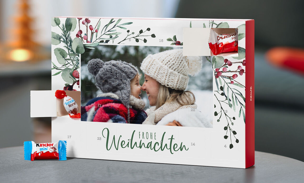 Adventskalender mit Süßigkeiten, umgeben von festlichem Grün und Weihnachtsmotiven