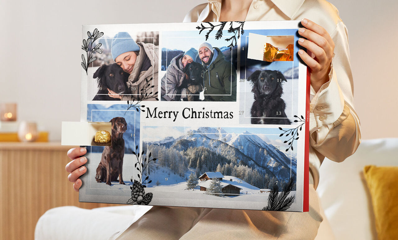 Eine Person hält ein kreatives Fotobuch mit Weihnachtsmotiven in den Händen.