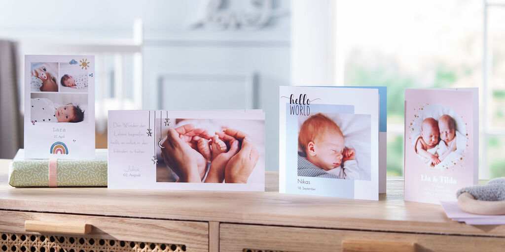 Verschiedene personalisierte CEWE Grußkarten und ein Fotobuch auf einem Tisch, ideal für Geschenke und Erinnerungen.