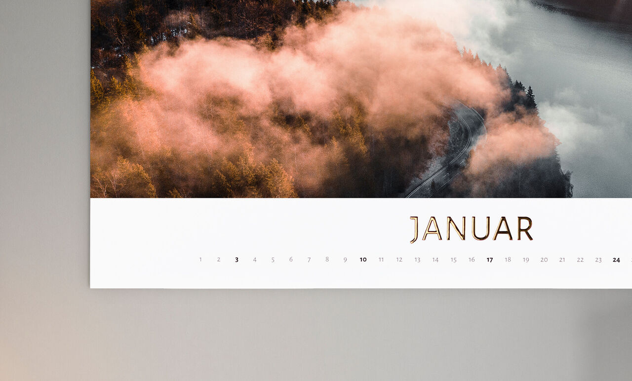 Kalenderblatt für Januar mit sanften Farben und Nebel über einem Wald.