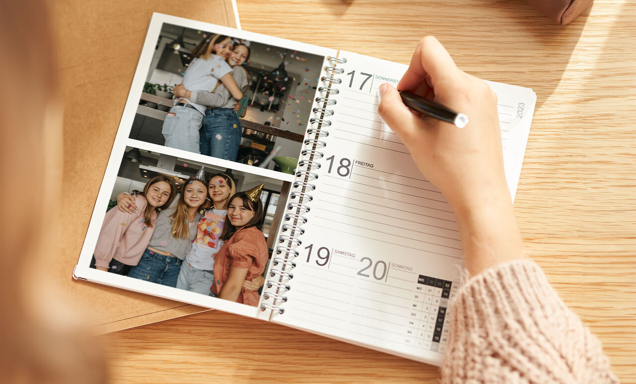 Junge Frau schreibt in einen Kalender mit Bildern von Freunden.