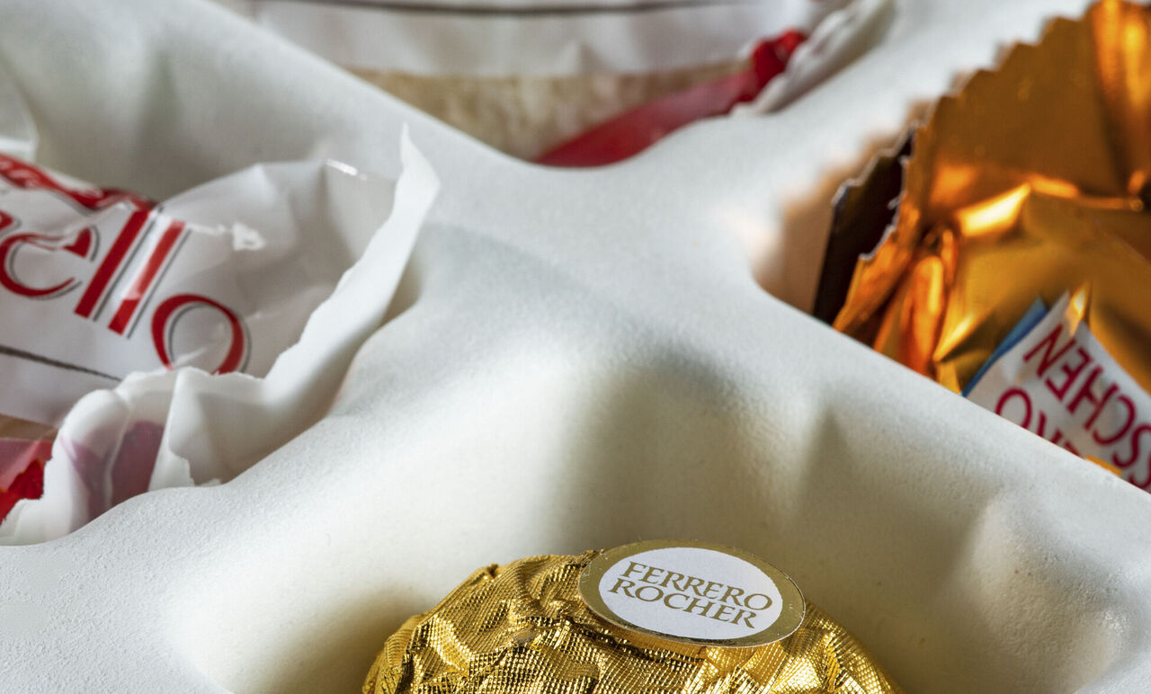 Ein brauner Ferrero Rocher Schokoladenkeks liegt in einer weißen Verpackung.