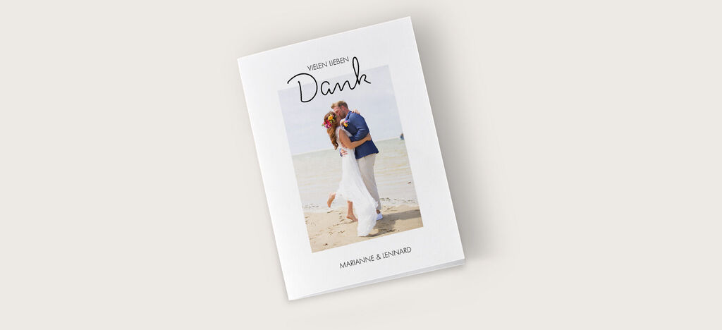 Hochzeitspaar am Strand, dankt Gästen liebevoll im CEWE Fotobuch.