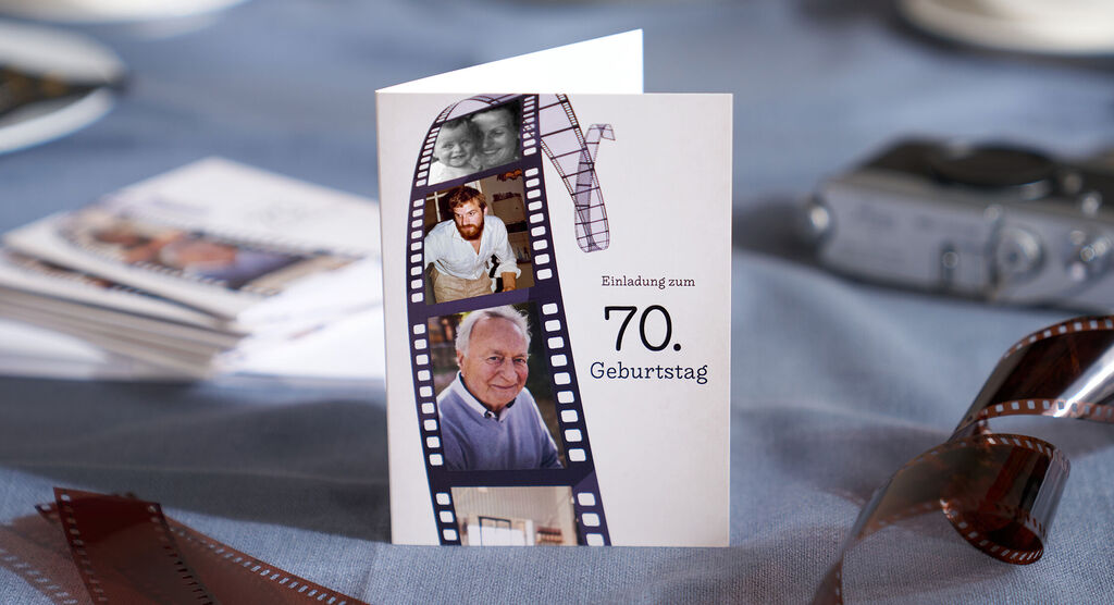 Auf einem feierlich geschmückten Tisch liegen personalisierte Einladungskarten in Vintage-Optik.