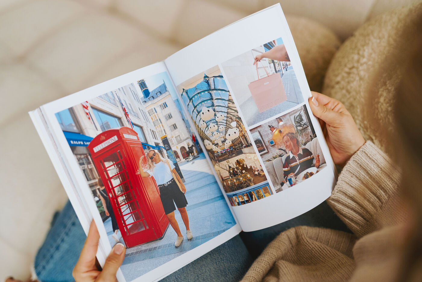 Eine Frau hält ein aufgeschlagenes Fotobuch in den Händen. Auf den Bildern sind Motive aus London zu sehen, wie eine rote Telefonzelle.