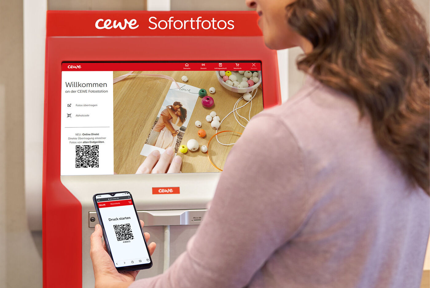 Eine Person steht vor einem CEWE Sofortfoto-Automaten und scannt ihren QR-Code, um Fotos zu bestellen. Auf dem Bildschirm sind bereits einige Fotos sichtbar.