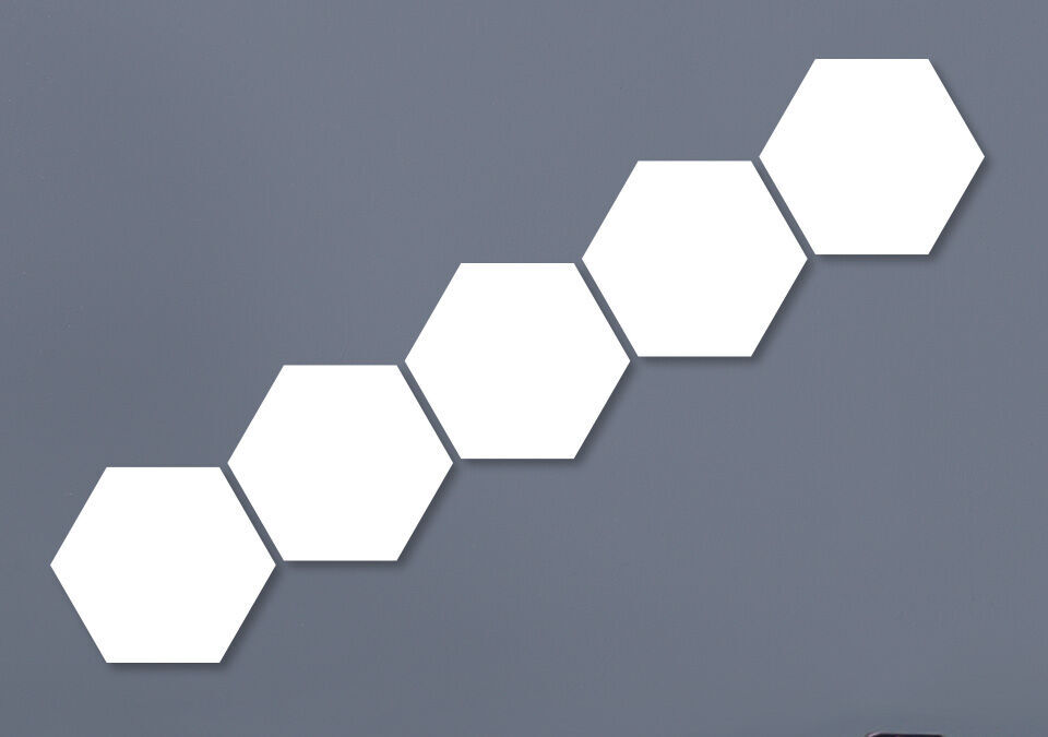 Fünf verbundene, leere Hexagonformen an einer grauen Wand